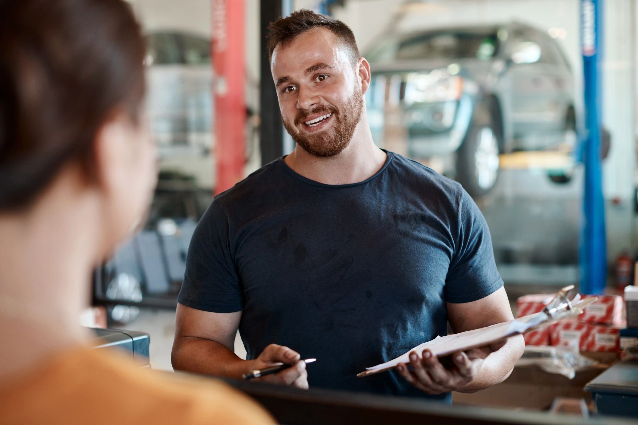 Customer speaking with mechanic at auto repair shop