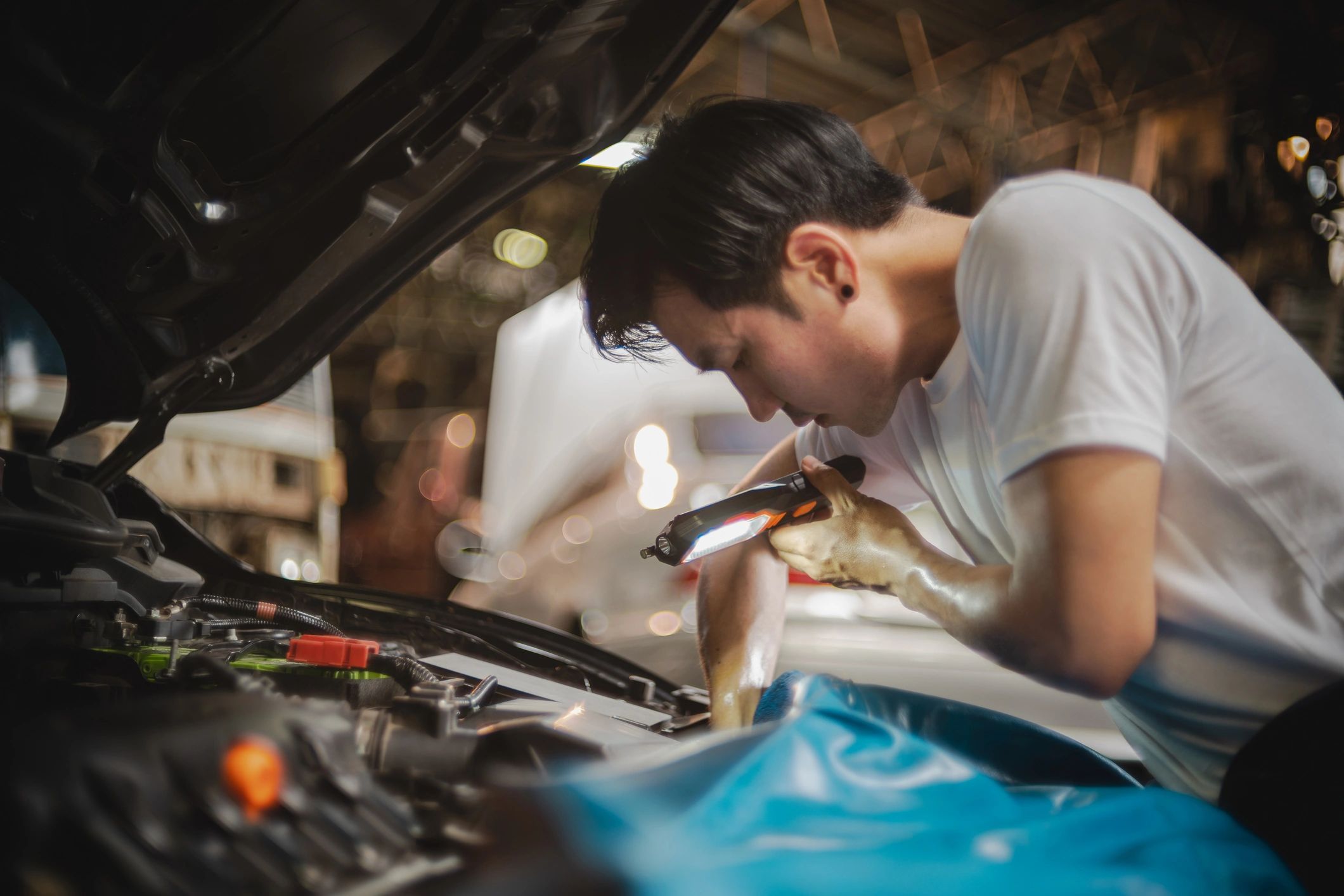 Technician examining a car engine during diagnostic service