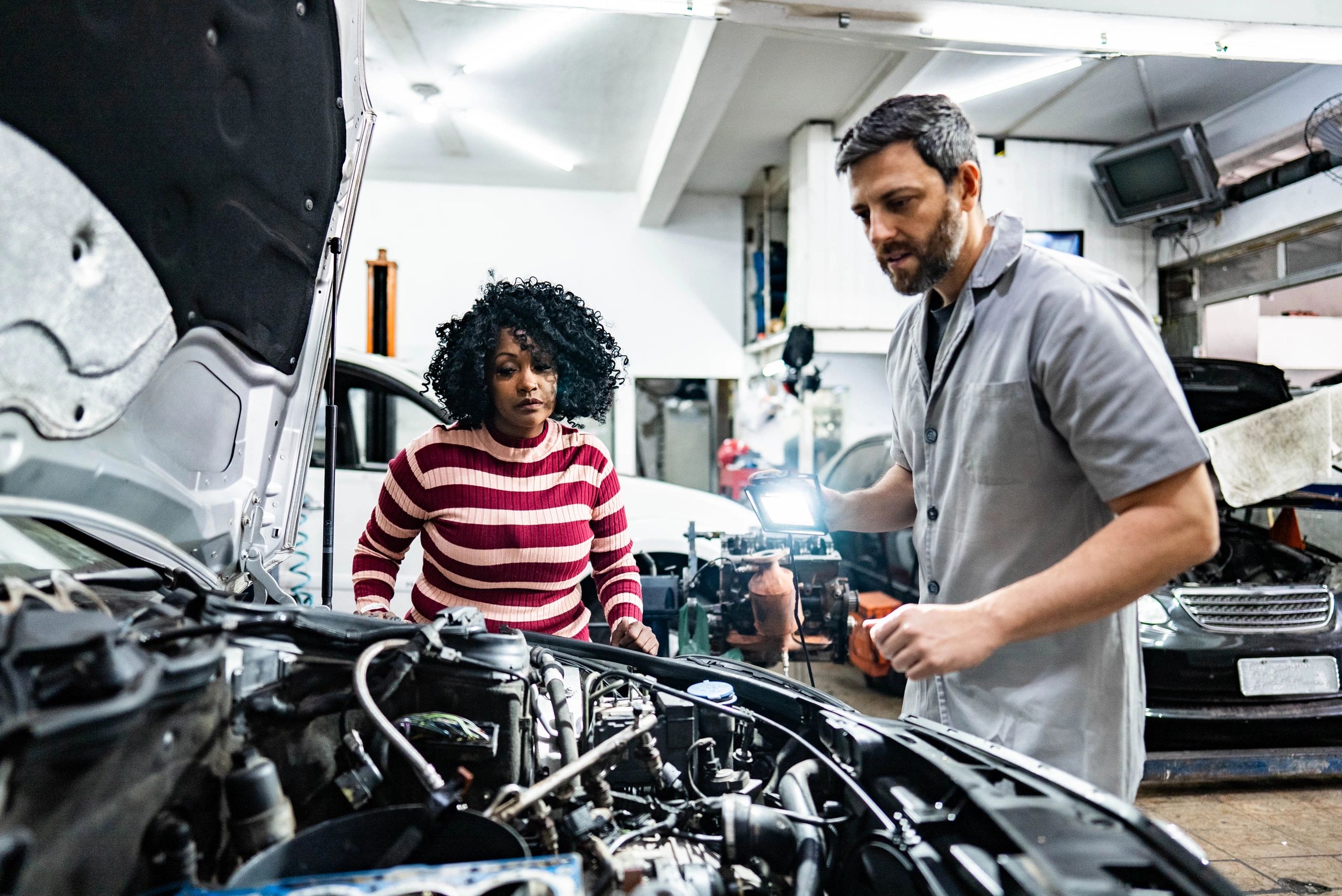 Mechanic talking with a customer in an auto repair shop